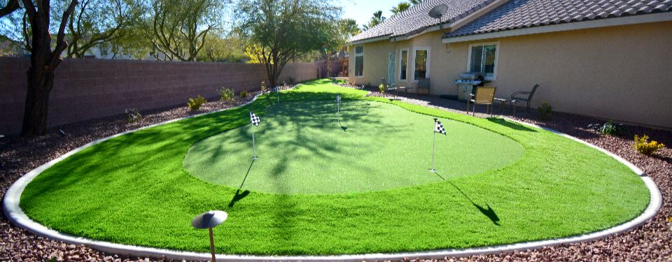 Backyard made of artificial grass, featuring a few golf holes.