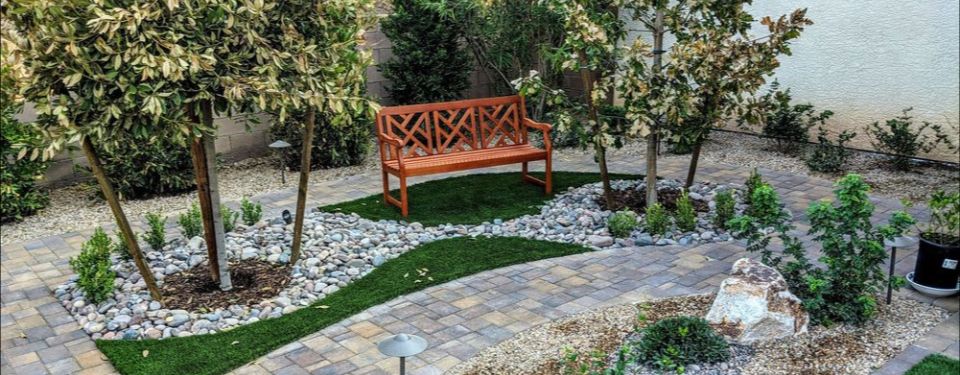 home landscaping with paved pathway and bench for sitting
