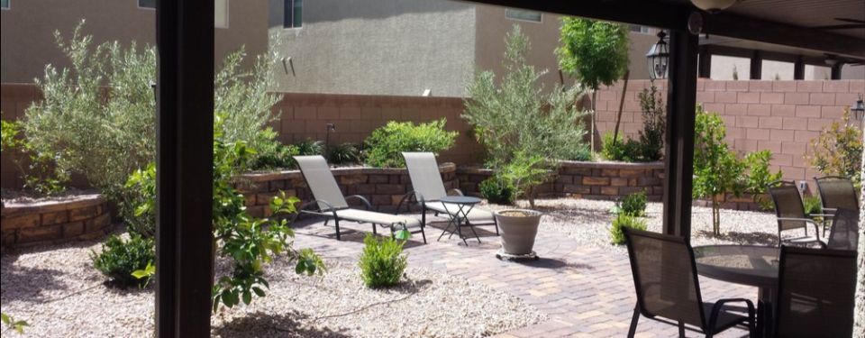 Backyard patio with table and lawn chairs.